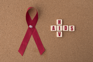 logo de la section: Un ruban rouge avec des lettres formant les mots VIH et AIDS